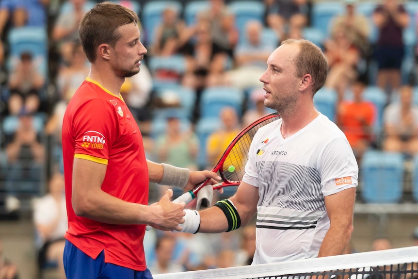 Alexander Cozbinov and Steve Darcis shake hands over the net after their ATP Cup match