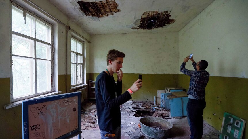 Visitors take pictures of an abandoned kindergarten