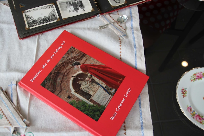 A book on a table near an open photo album