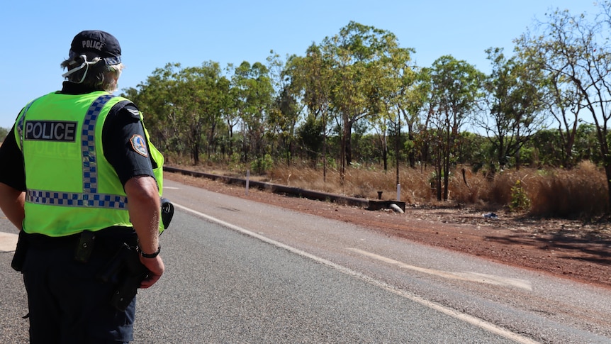 A police officer stands on the Stuart Highway