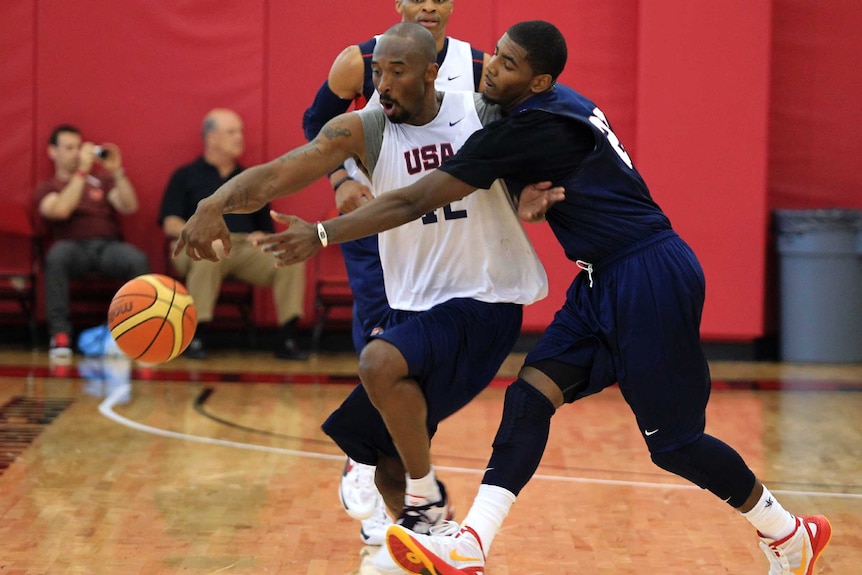 Kyrie Irving stretches across Kobe Bryant to try to take the ball off him.