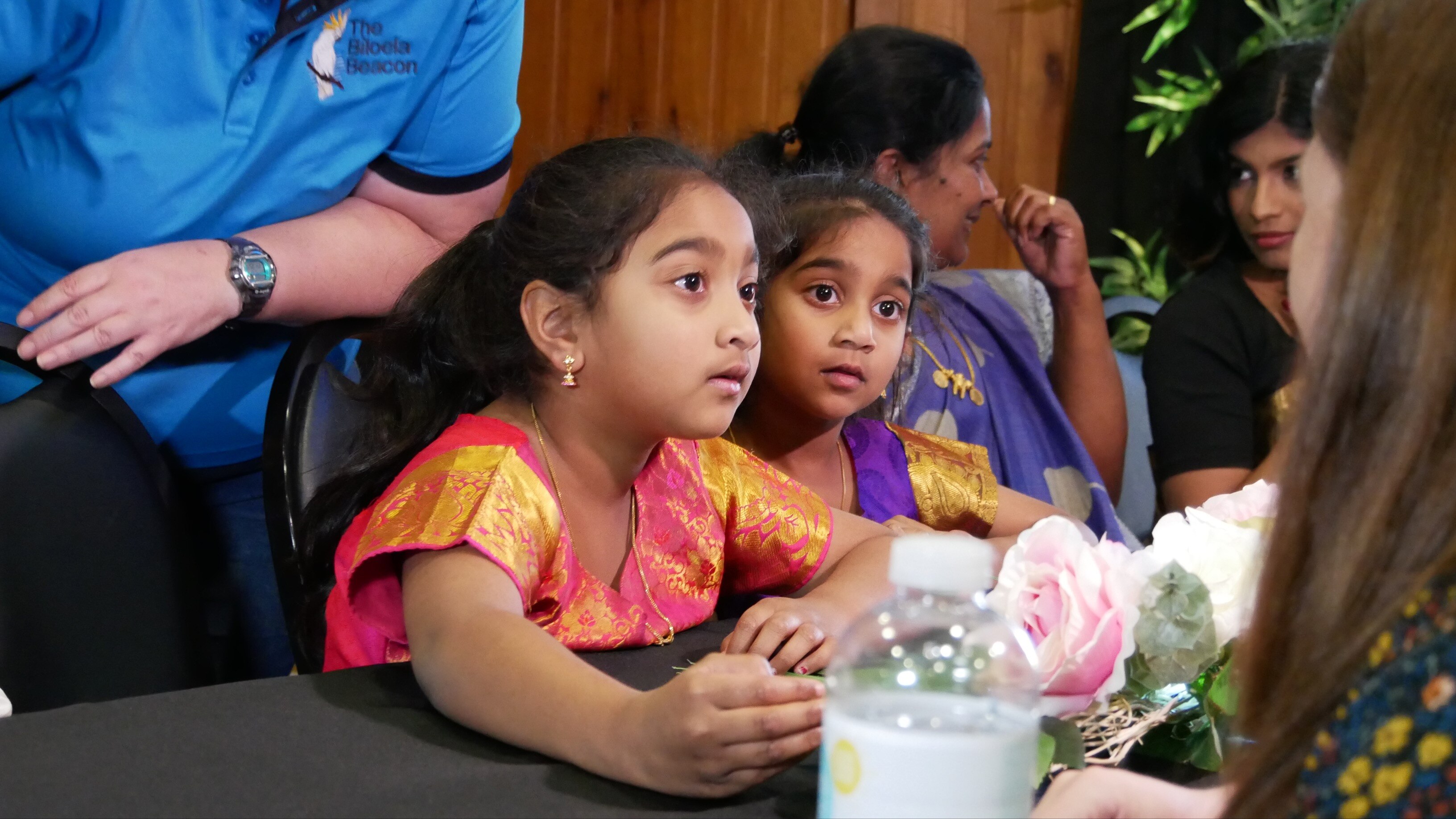 Two young girls sit at a table