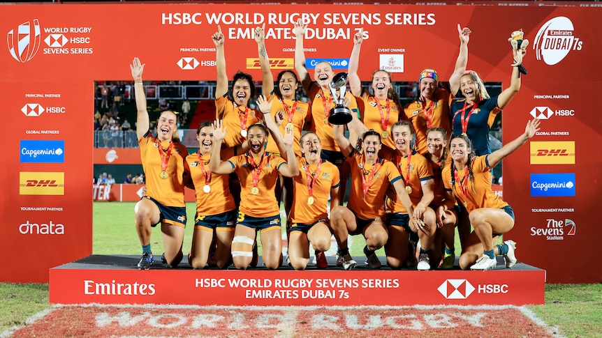 Australia's women's rugby sevens team claiming their winning tournament trophy in Dubai