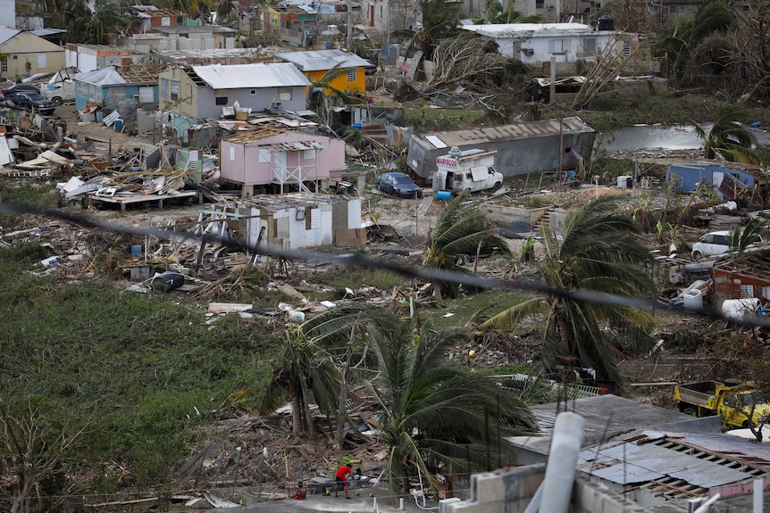 Debris and damaged houses are seen everywhere.