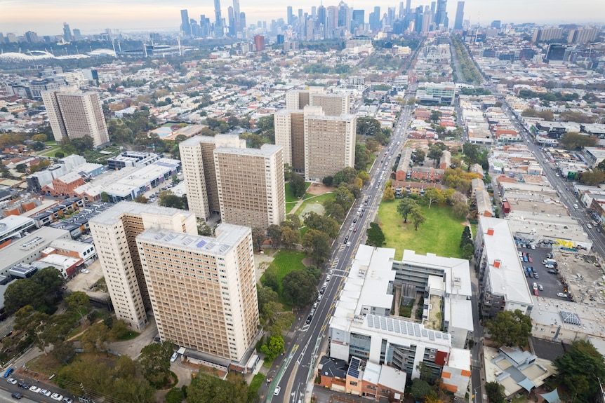A drone picture showing part of Richmond, with high-rise public housing towers in the foreground and a city skyline behind.