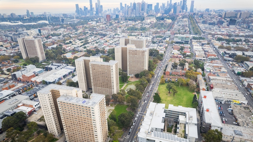 A drone picture showing part of Richmond, with high-rise public housing towers in the foreground and a city skyline behind.