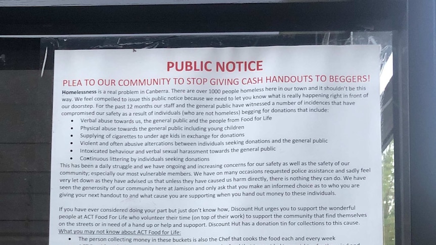 A poster stuck inside a window asking community members to stop giving cash handouts to beggars.