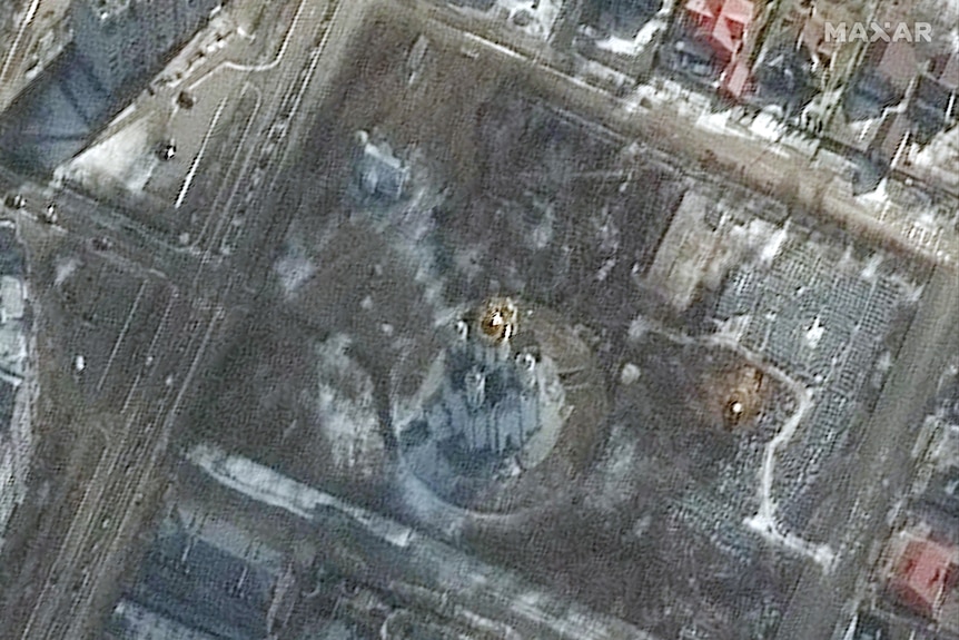 A satellite image of a large church surrounded by grass and a small trench.