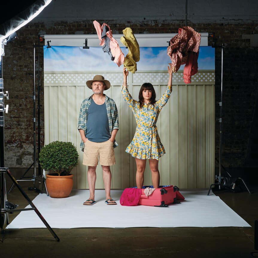 Two theatre actors on a photo studio backdrop is a suburban house