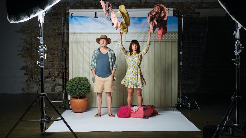 Two theatre actors on a photo studio backdrop is a suburban house