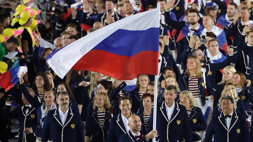 Athletes walk behind the Russian flag
