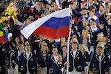 Athletes walk behind the Russian flag