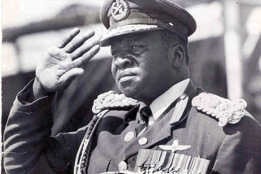 Black and white photo of man in a military uniform saluting.