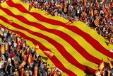 People holding Spanish flags march alongside a giant flag in Barcelona.