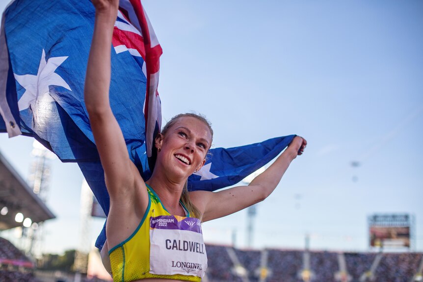 Abbey Caldwell holds an Australian flag