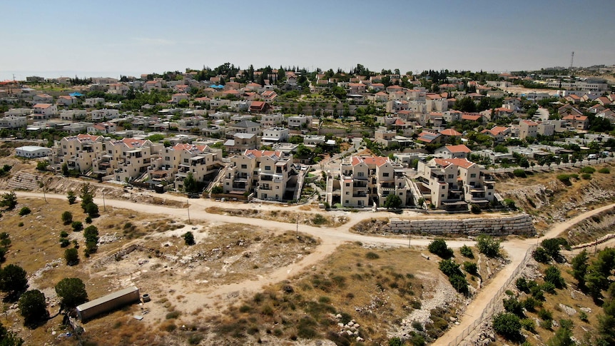 An aerial view shows houses and units in the West Bank, with dirt roads leading between