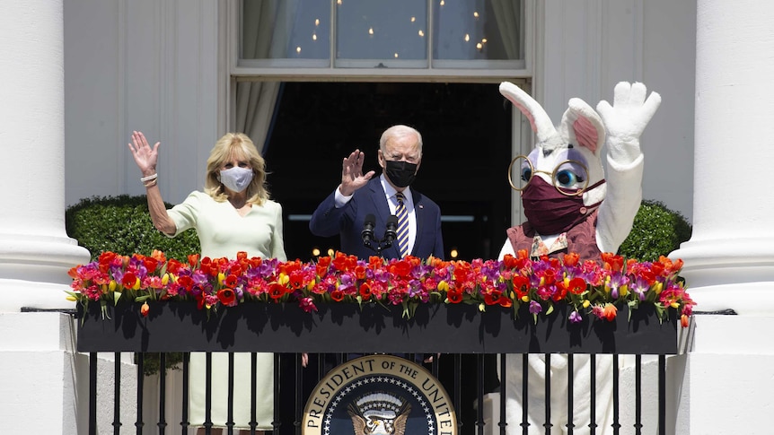 U.S. President Joe Biden, First Lady Jill Biden and someone in a rabbit costume wave from the Truman Balcony of the White House