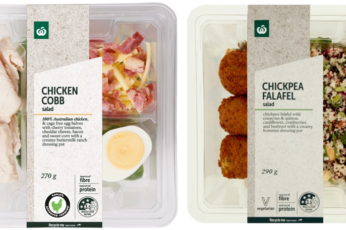 Packages of chicken cobb salad and chickpea falafel salad, side-by-side against a white backdrop.