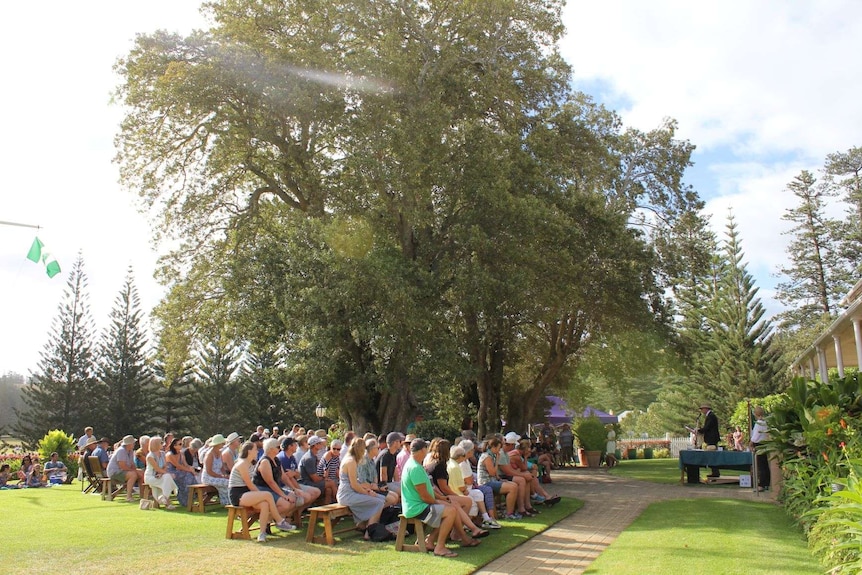 a group of people gather under a tree for Australia Day