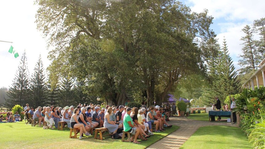 a group of people gather under a tree for Australia Day