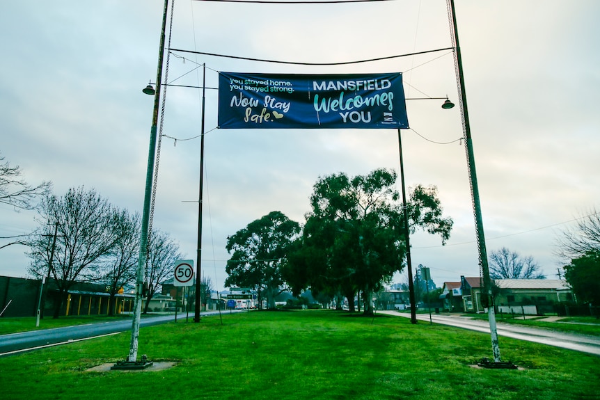 A sign welcoming people to Mansfield on an overcast day.