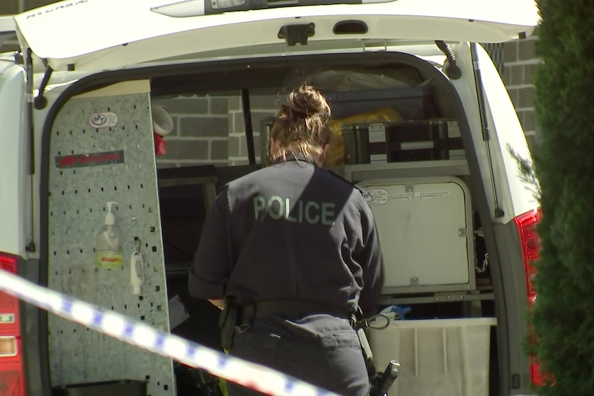 a police woman looking in the back of a van