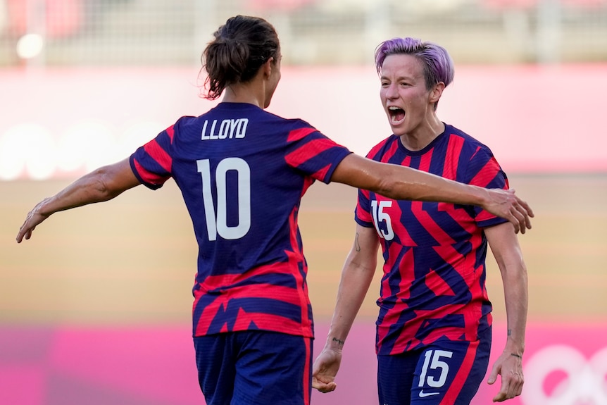 Two women celebrate during a football match at the Olympics.