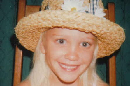 Lisa Munro, smiling and wearing a pretty hat