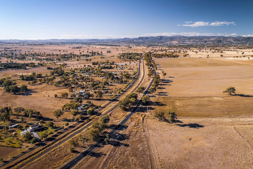 An aerial view of a train line running through wide open country.