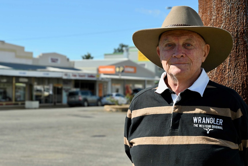 A man stands in Biggenden's main street wearing a hat.