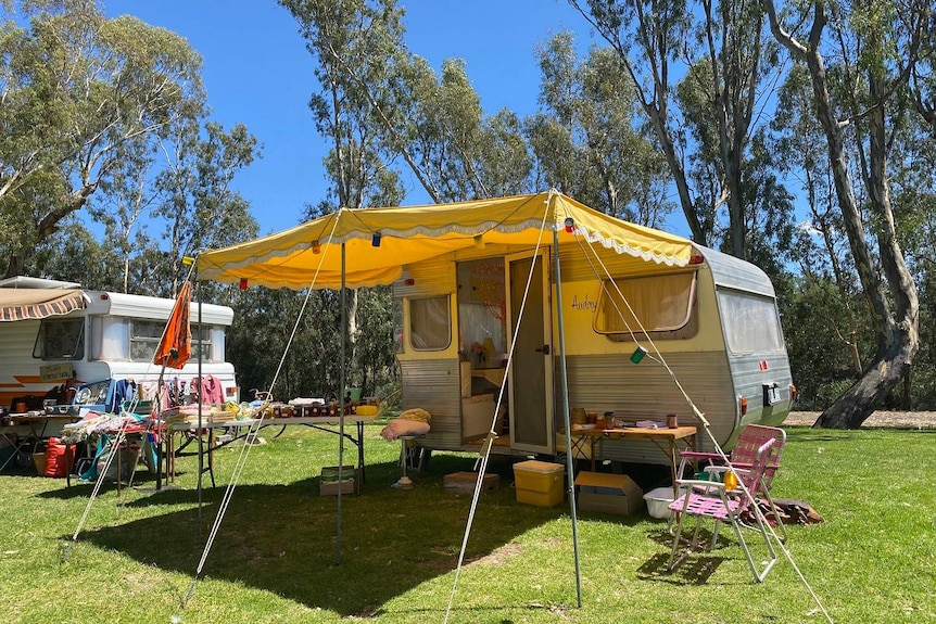 old caravan with an awning set up on a sunny day