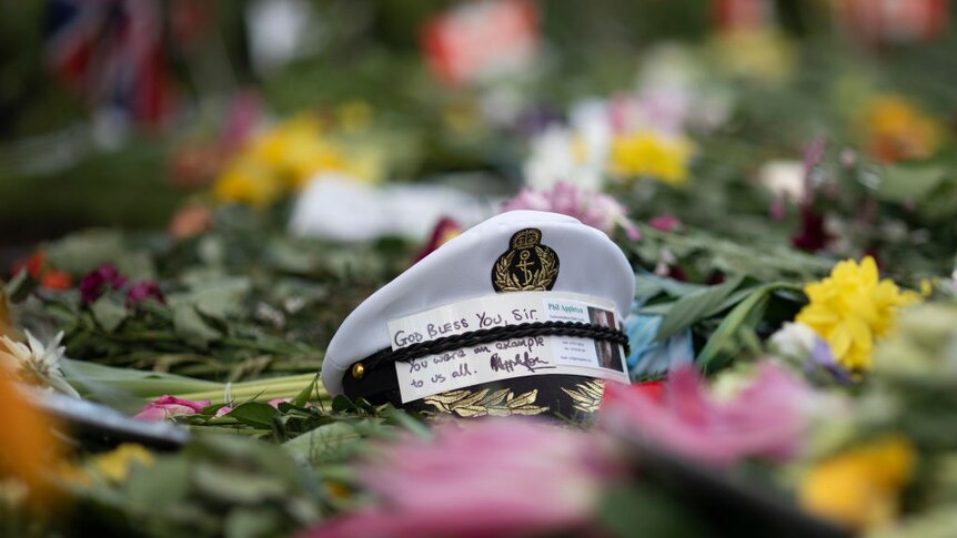 A navel cap sits amongst floral tributes to Prince Philip, Duke Of Edinburgh outside Windsor Castle.