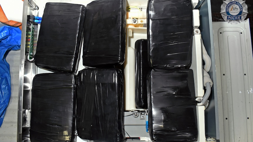 Six cases wrapped in black wrap. 