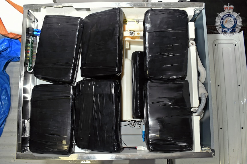 Six cases wrapped in black wrap. 