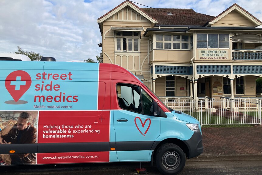 mobile medical van parked outside GP clinic building 