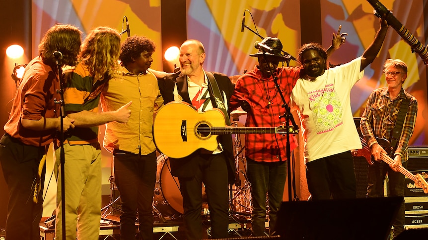 Members of King Stingray arm in arm with Colin Hay onstage at the APRA Music Awards after their performance.