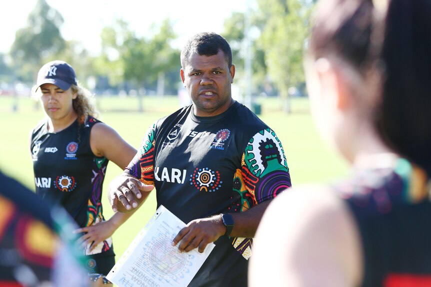 A coach addresses his players during a rugby league training session
