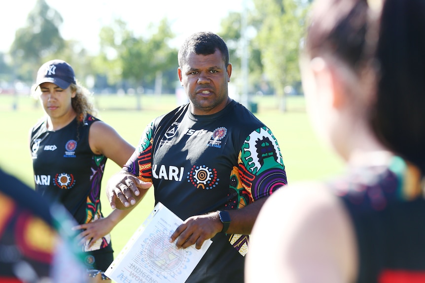 A coach addresses his players during a rugby league training session
