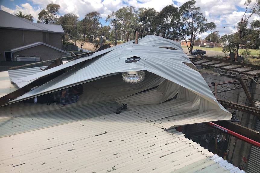 Metal roof folded back on itself after a storm
