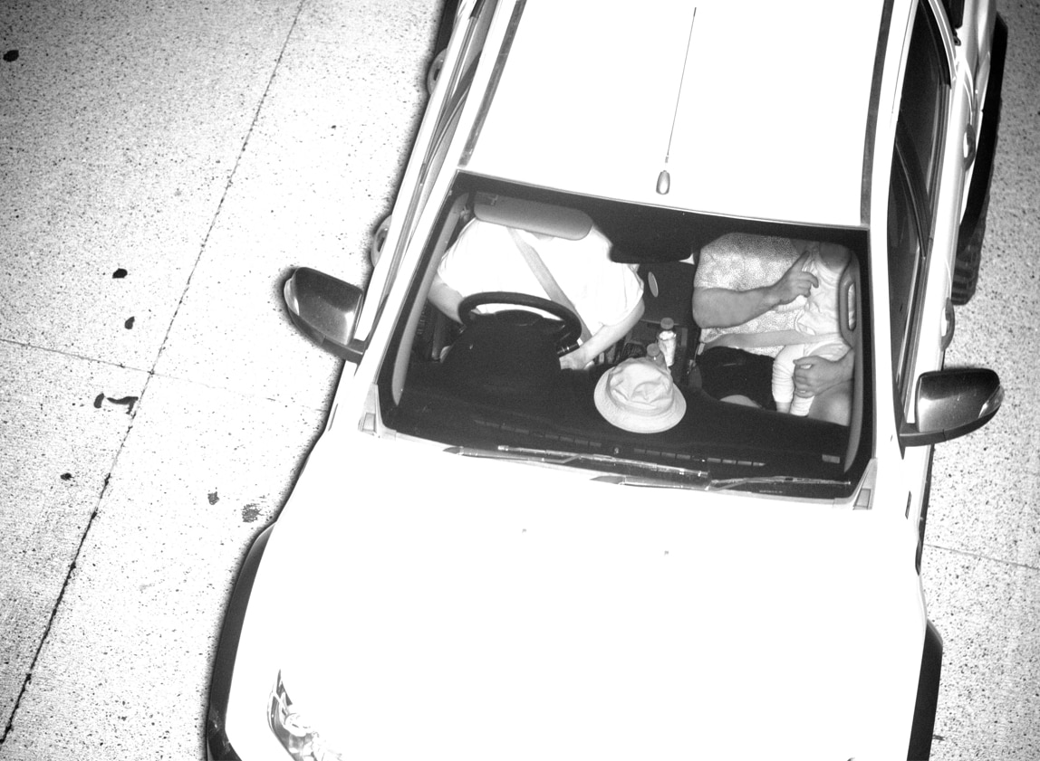 Surveillance cameras show a child sitting on the lap of a passenger in the front seat. Both are wearing the one seatbelt