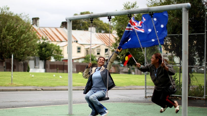 Two Indigenous Australians fly the Aboriginal and Australian flag (Getty Images: Kristian Dowling)