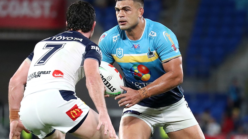NRL player David Fifita, with ball in hand, approaches a defender