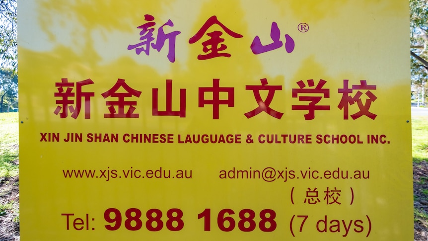 A yellow sign with red writing advertising the language school.