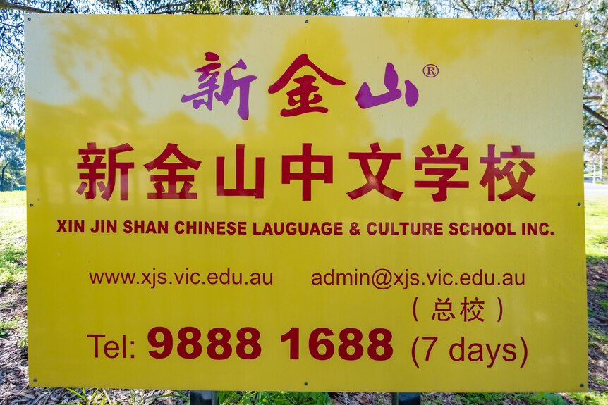 A yellow sign with red writing advertising the language school.