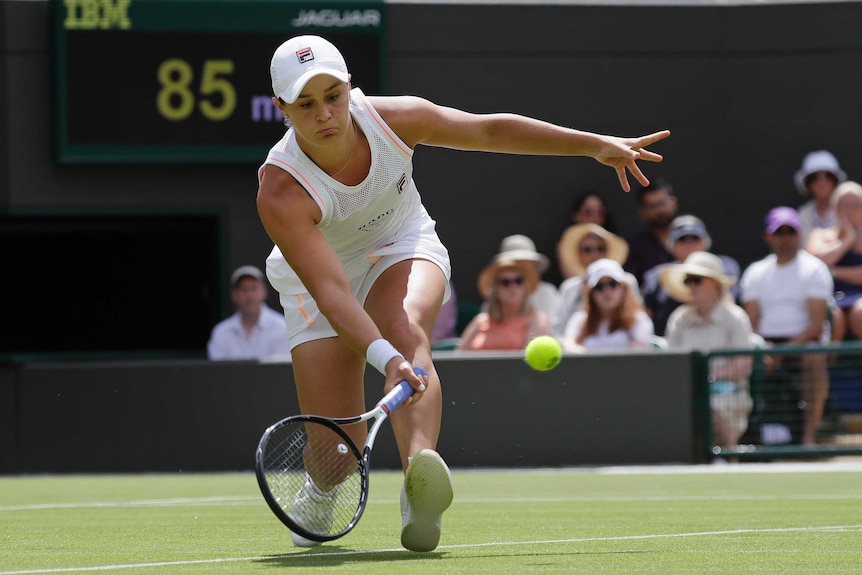 Ashleigh Barty plays a low forehand return in a first-round match at Wimbledon