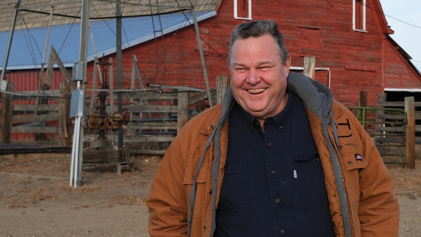 US Senator Jon Tester standing in front of a barn. 