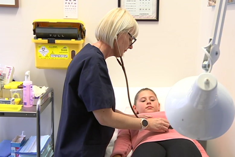 doctor treats young female patient on stretcher