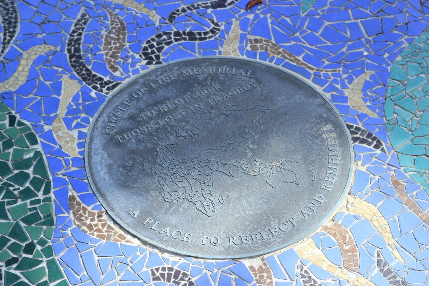 A circular plaque dedicated to people who died in tragic circumstances.