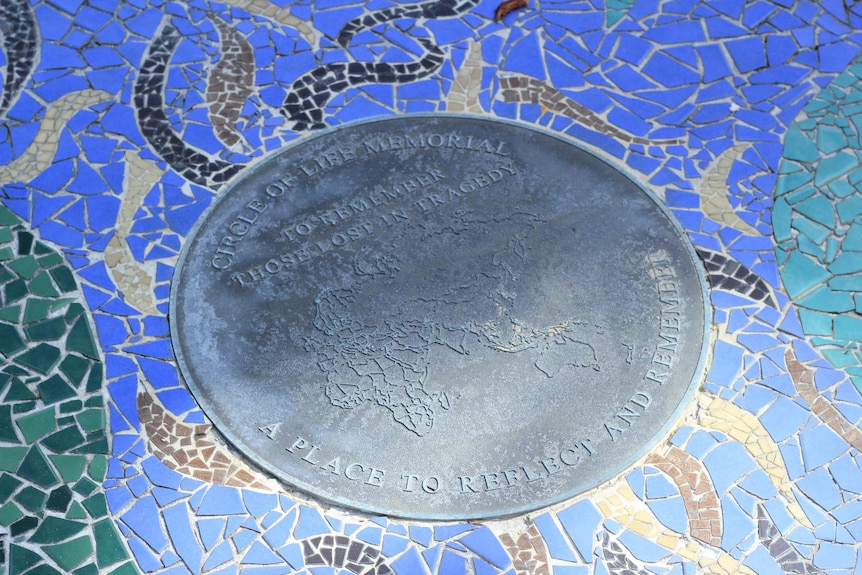 A circular plaque dedicated to people who died in tragic circumstances.