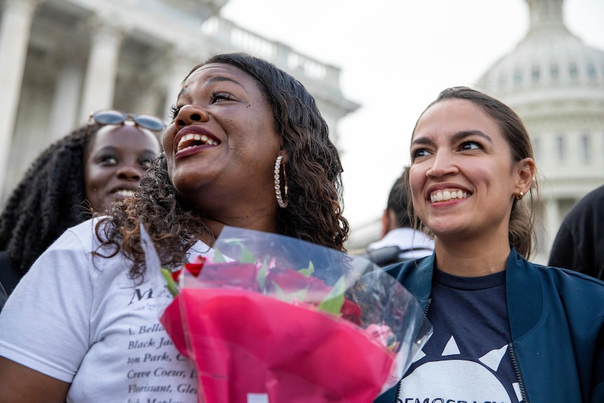 Rep. Cori Bush, D-Mo., and Rep. Alexandria Ocasio-Cortez, D-N.Y., smile 